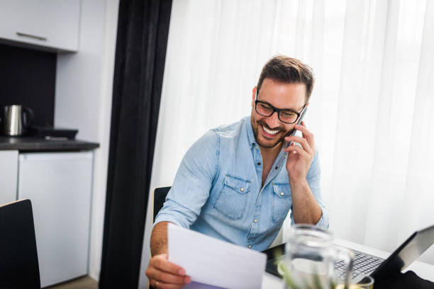 istock Handsome man using laptop computer at home, drinking juice and coffee in the morning 1006095134