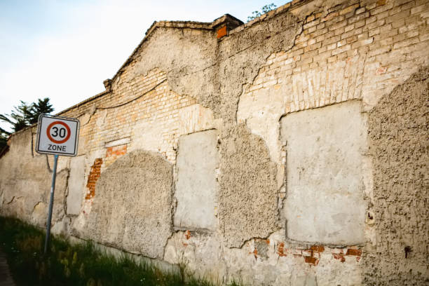 istock old stone wall with shuttered windows and a road sign 1006095314