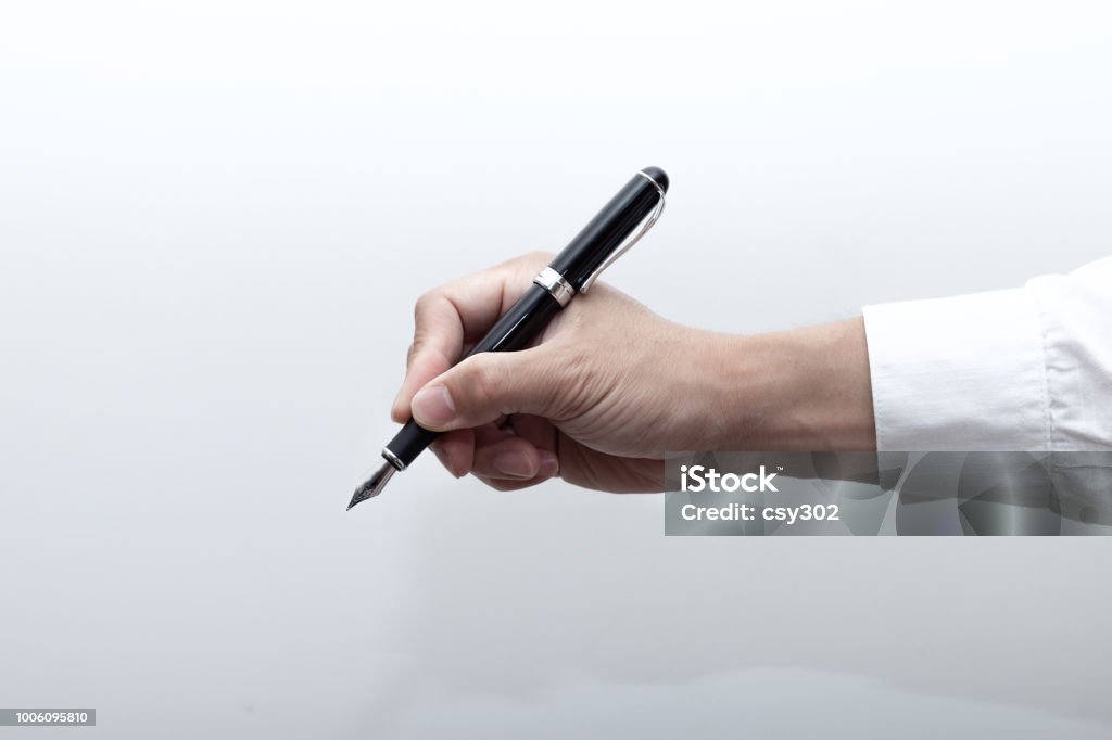 A hand holding a fountain pen Fountain Pen Stock Photo