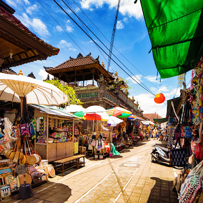 Ubud street market stalls selling a vast array of souvenirs, textiles and craft products on a sunny day in Bali Indonesia