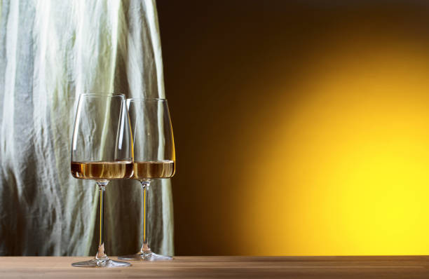 Glasses of white wine on a yellow background. Copy space.