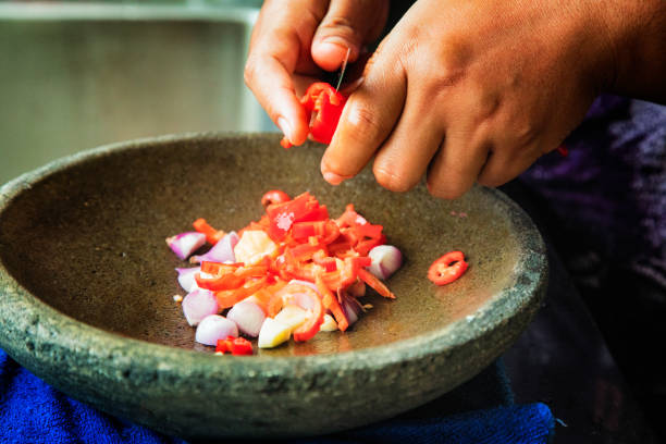 istock Indonesian Ayam Goreng preparation slicing chilies in mortar 1006107670