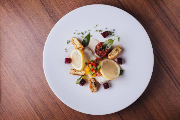 istock Cod fish fillet pan baked in lemon with cos, beet root, string bean, potato and champagne white wine sauce 1006115562