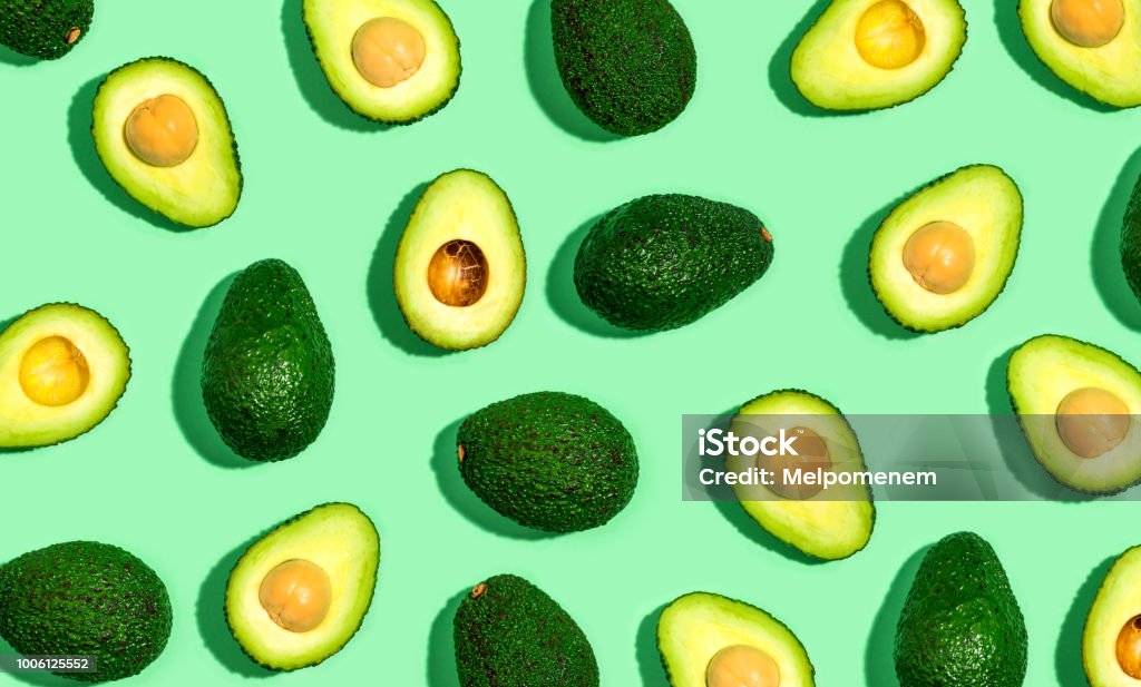 Fresh avocado pattern on a green background Fresh avocado pattern on a green background flat lay Avocado Stock Photo