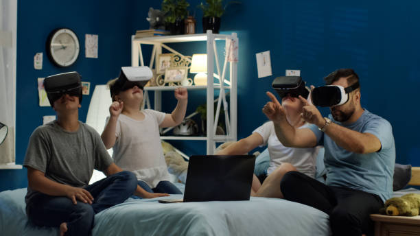 istock Family in VR glasses sitting on bed 1006143892