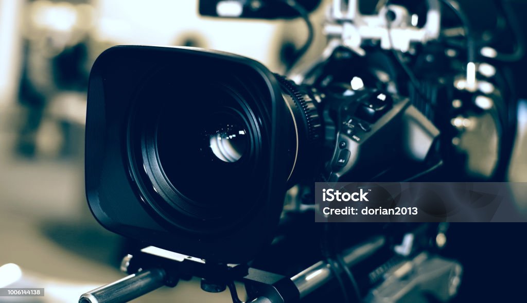 Modern video camera Modern video camera with microphone on blurred background Camera Operator Stock Photo