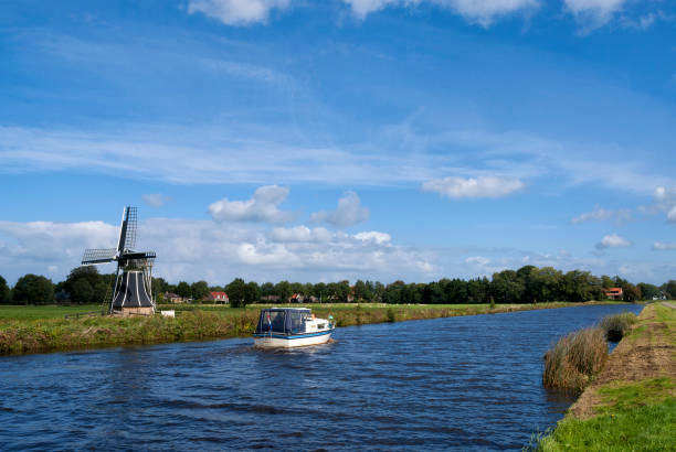 Boat sails along the Tjongermill windmill near Mildam in the Dutch province Friesland
