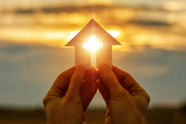 istock Hands with paper prayer house in the hands . 1006147382