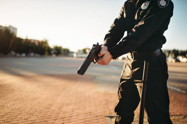 istock Male cop in uniform with gun in hands 1006151052