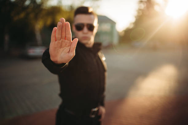 istock Serious police officer shows a hand stop sign 1006151232