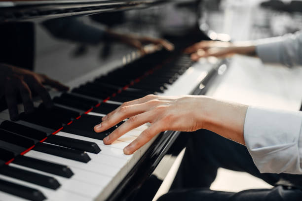 istock Male pianist hands on grand piano keyboard 1006151846