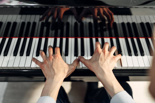 istock Male pianist hands on grand piano keyboard 1006151956