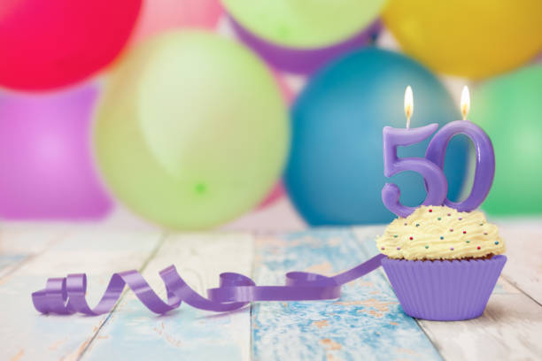istock 50 anniversary celebration muffin with candle 1006153310