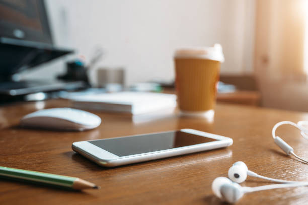istock White phone, headphones, mouse and cup of coffee 1006168106