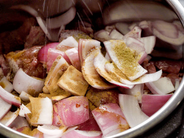 istock Raw Onions, Pork and Seasonings Loading Into an Multi Cooker 1006187050