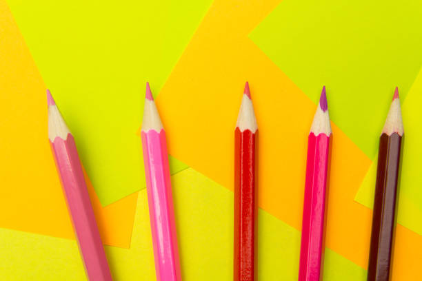 istock Colored pencils on the multi-colored paper background.Concept back to school. Geometric paper texture background. Template 1006189956