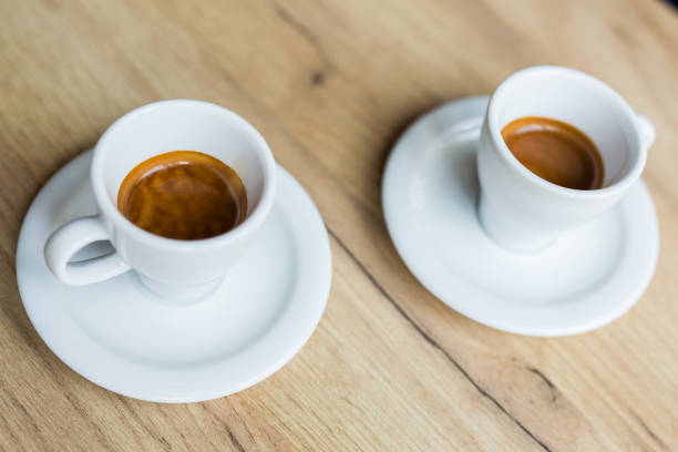 istock Two white cups of coffee on a table 1006191408