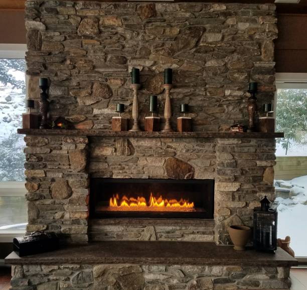 Cozy, Stone Fireplace With Flames Aglow in Winter stock photo