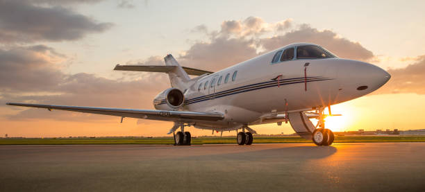 business-jet auf rampe mit sonne im hintergrund - firmenflugzeug stock-fotos und bilder