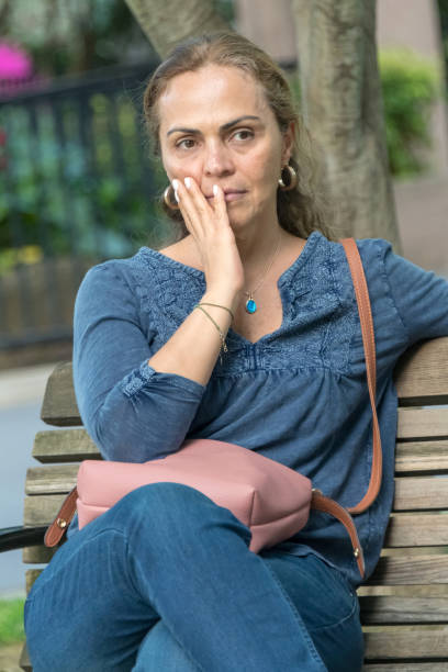 istock Mature woman sitting in a park bench 1006205360
