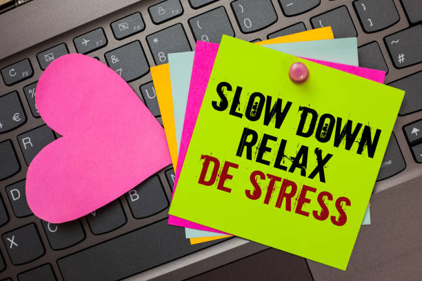 istock Text sign showing Slow Down Relax De Stress. Conceptual photo Have a break reduce stress levels rest calm Bright colorful written papers pinch by pin pink heart on computer keyboard. 1006205476