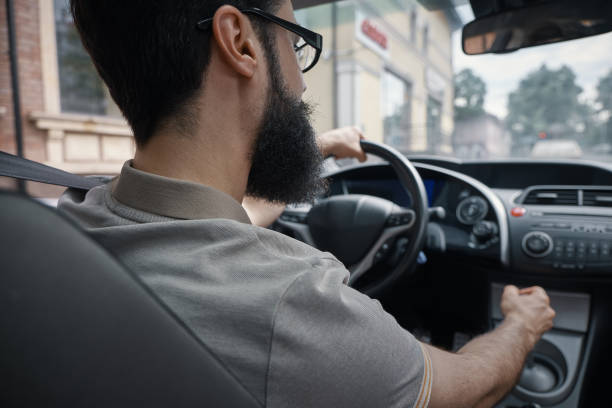 istock Handsome man driving the car side view 1006208990