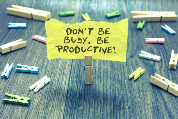 istock Handwriting text Don t not Be Busy. Be Productive. Concept meaning Work efficiently Organize your schedule time Paperclip hold written torn page many clips laid on bluish wooden floor. 1006216278