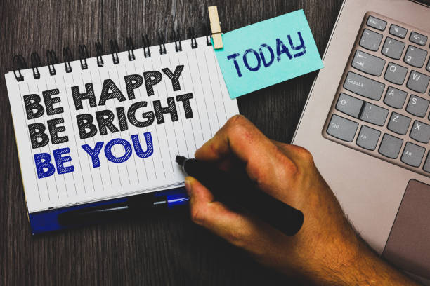 Word writing text Be Happy Be Bright Be You. Business concept for Self-confidence good attitude enjoy cheerful Paperclip grip sticky note with text hand hold pen computer on wooden desk word escribir texto ser feliz ser brillante ser usted. concepto de negocio para la buena actitud de confianza en sí mismo disfrutar de alegre nota adhesiva de sujeción de clip con equipo texto mano sostenga la pluma escritorio de madera.