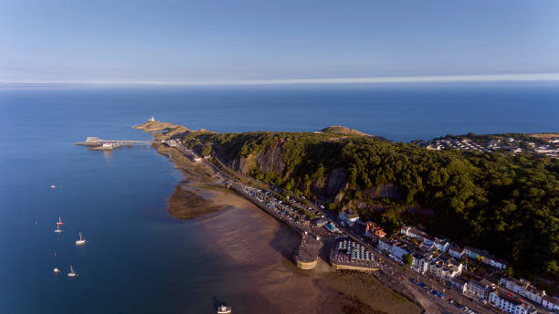 Mumbles headland from above Editorial Swansea, UK - July 22, 2018: Aerial view of the Mumbles in Swansea, featuring the slipway, knab rock, the pier and lighthouse swansea stock pictures, royalty-free photos & images