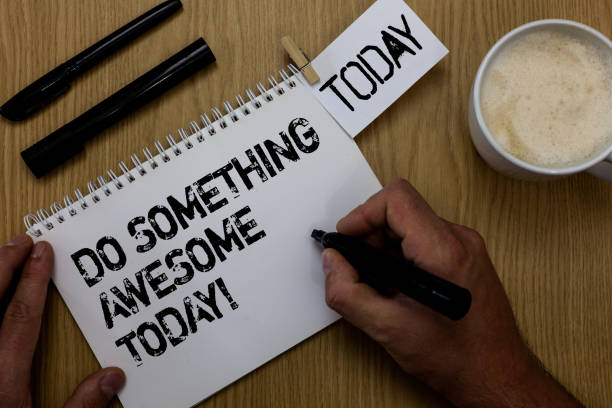 istock Text sign showing Do Something Awesome Today. Conceptual photo Make an incredible action motivate yourself Paperclip retain written notepad hand hold marker coffee black pen on woody desk. 1006226462