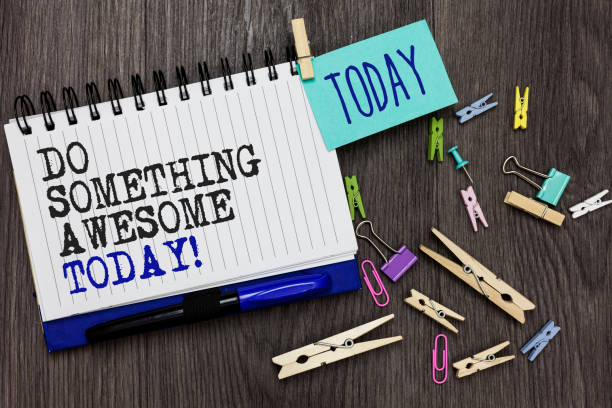istock Writing note showing Do Something Awesome Today. Business photo showcasing Make an incredible action motivate yourself Different paperclip on woody table pinch on written notepad blue pen. 1006229090