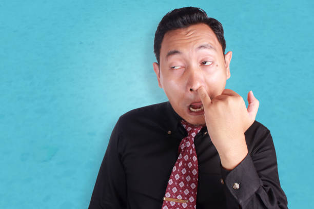 młody azjatycki człowiek zbierający jego nos - picking nose zdjęcia i obrazy z banku zdjęć