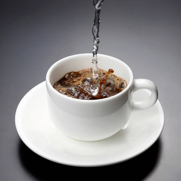 istock boiled water from the kettle is poured into a white Cup for coffee 1006232218