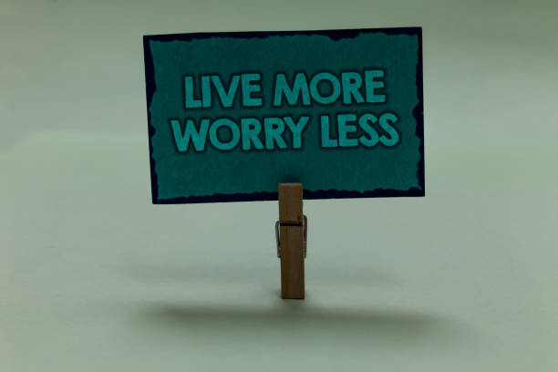 istock Writing note showing Live More Worry Less. Business photo showcasing Have a good attitude motivation be careless enjoy life paperclip grip black lined green page with outlines grey background. 1006232804