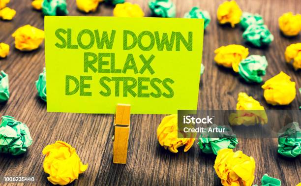 Handwriting Text Slow Down Relax De Stress Concept Meaning Have A Break Reduce Stress Levels Rest Calm Paperclip Retain Written Words Yellow Paper Paper Lobs Laid On Wooden Floor Stock Photo - Download Image Now