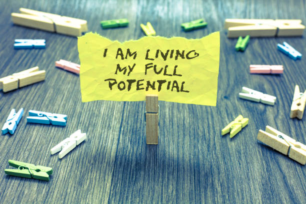 istock Handwriting text I Am Living My Full Potential. Concept meaning Embracing opportunities using skills abilities Paperclip hold written torn page many clips laid on bluish wooden floor. 1006238106