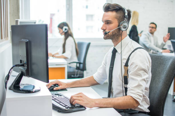 istock Attractive young man working in a call center with his colleagues 1006241358