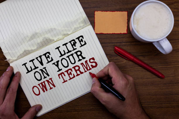istock Handwriting text writing Live Life On Your Own Terms. Concept meaning Give yourself guidelines for a good living Sticky note red pen coffee with coffee mug hand hold pen with written words. 1006243484