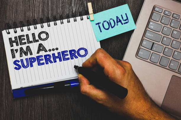 istock Word writing text Hello I am A ... Superhero. Business concept for Special powers Cartoon character Customs strenght Paperclip grip sticky note with text hand hold pen computer on wooden desk. 1006247520