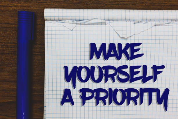 istock Writing note showing Make Yourself A Priority. Business photo showcasing Think in your own good first personal development Written white notepad on grey wooden background beside blue marker. 1006250048