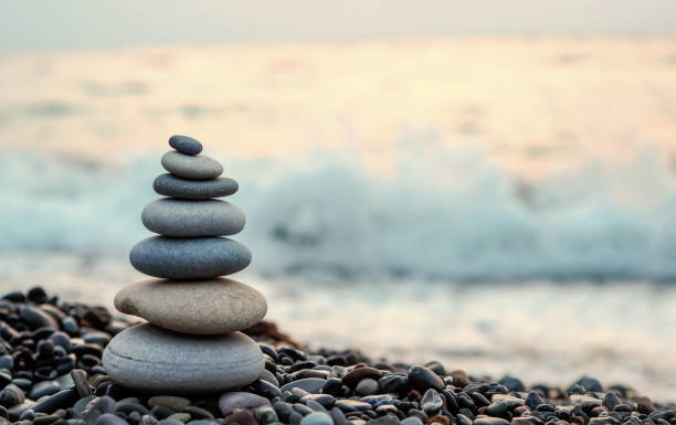 hecho de torre de piedra en la playa y desenfoque de fondo - pirámide estructura de edificio fotografías e imágenes de stock