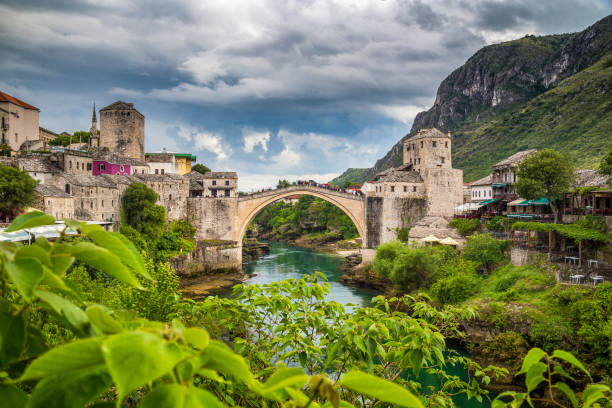 Old town of Mostar with famous Old Bridge (Stari Most), Bosnia and Herzegovina Panoramic view of the historic town of Mostar with famous Old Bridge (Stari Most), a UNESCO World Heritage Site since 2005, on a rainy day with dark clouds in summer, Bosnia and Herzegovina stari most mostar stock pictures, royalty-free photos & images