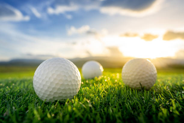 istock close up the golf ball on the green background with sunset 1006268540