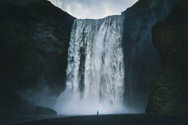 istock Hiker at gigantic Skogafoss waterfall in Iceland 1006268650