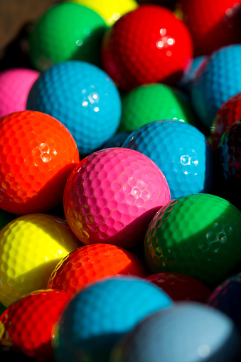 Golf balls in primary colors in basket