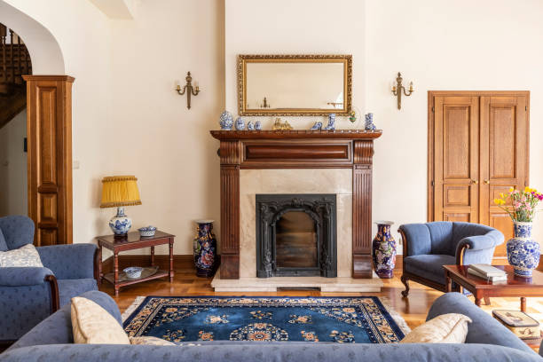 espejo en marco de oro por encima de la chimenea en interior sofisticado salón de la casa inglesa. foto real - living room blue sofa carpet fotografías e imágenes de stock