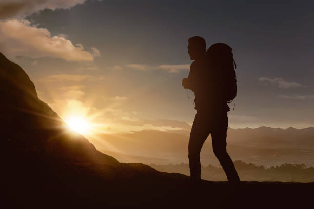 istock Silhouette of backpacker man hiking the mountain 1006322100