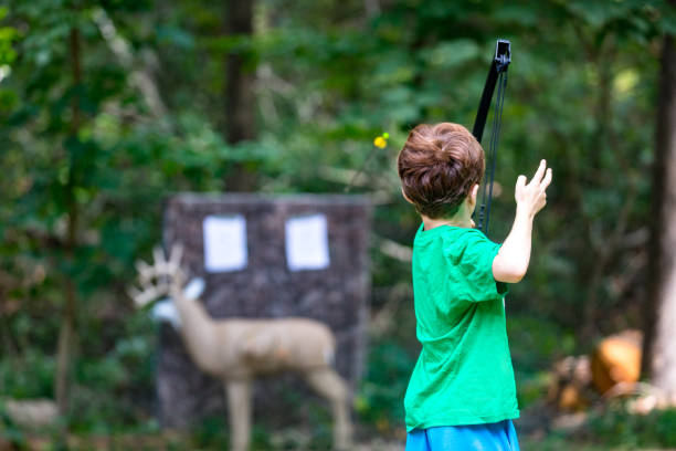 chłopiec strzelanie łuk na deer target - child outdoors bow horizontal zdjęcia i obrazy z banku zdjęć