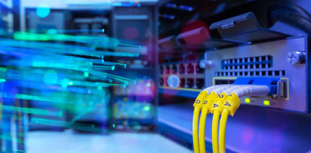 Fiber optic cable and Network switch 24 port gigabit blending with fiber optic cable and lighting of fiber optics in network center room stock photo