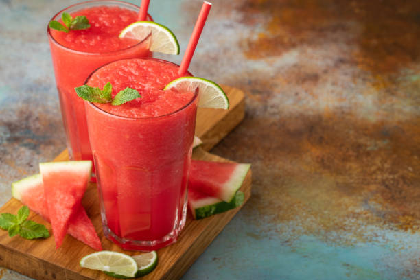 istock Watermelon slushie with lime, summer refreshing drink in tall glasses on a blue rusty background. with copy space 1006352904